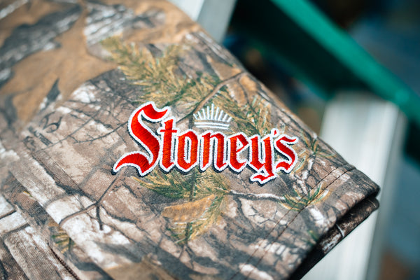 Camouflage-patterned product with 'Stoney's' logo on a blurred background